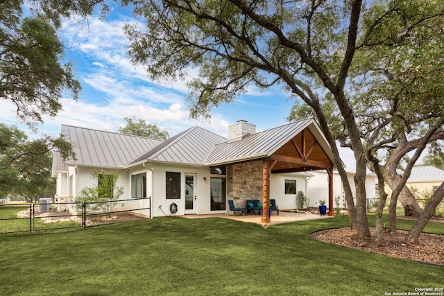 1133 Horseshoe Fls, Bandera, TX 78003 - rear view of house featuring a standing seam roof, metal roof, a chimney, stucco siding, and a patio