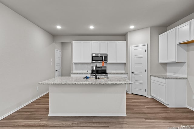 6610 Lowrie Block, San Antonio, TX 78239 - kitchen with appliances with stainless steel finishes, a sink, recessed lighting, a kitchen island with sink, and white cabinets