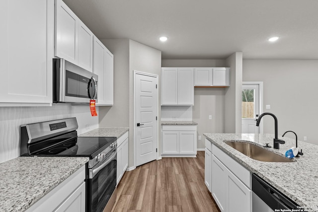 6610 Lowrie Block, San Antonio, TX 78239 - kitchen with appliances with stainless steel finishes, a sink, light wood finished floors, white cabinets, and recessed lighting