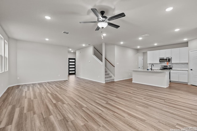 6610 Lowrie Block, San Antonio, TX 78239 - unfurnished living room featuring recessed lighting, a ceiling fan, a sink, light wood-style flooring, and stairway