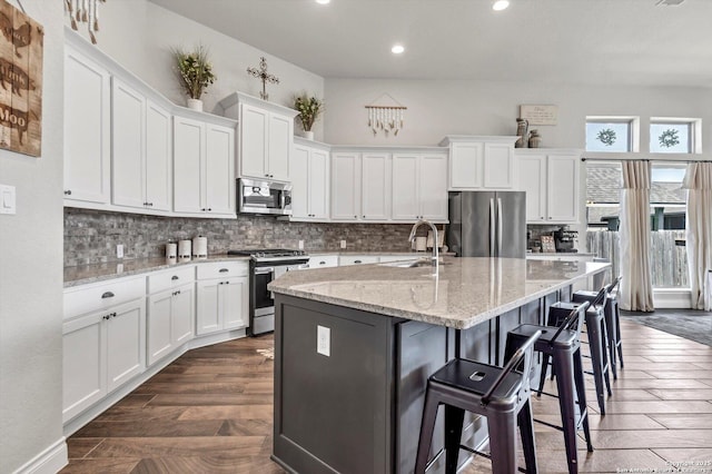 2977 Grove, Seguin, TX 78155 - kitchen featuring stainless steel appliances, white cabinets, recessed lighting, tasteful backsplash, and a center island with sink