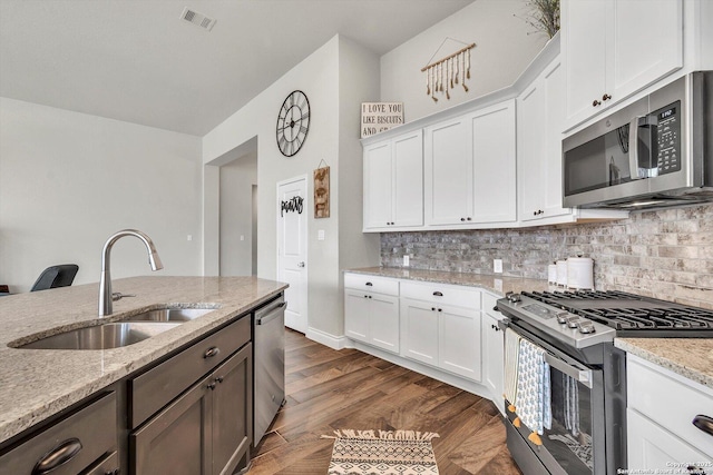 2977 Grove, Seguin, TX 78155 - kitchen with stainless steel appliances, a sink, decorative backsplash, light stone countertops, and white cabinets