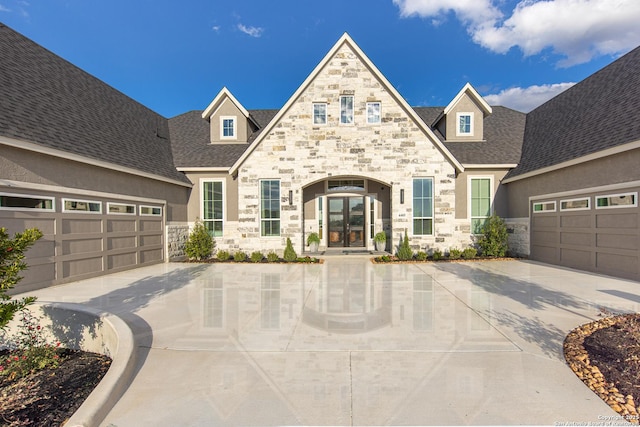 411 Poe Pkwy, Castroville, TX 78009 - view of front facade featuring stone siding, french doors, driveway, and roof with shingles