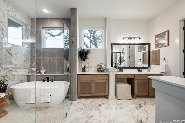 411 Poe Pkwy, Castroville, TX 78009 - full bath with marble tiled flooring, a freestanding bath, vanity, a walk in shower, and tile walls
