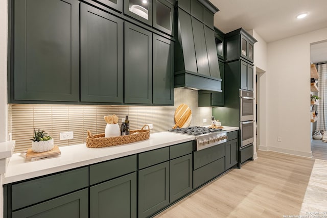411 Poe Pkwy, Castroville, TX 78009 - kitchen featuring green cabinetry, stainless steel appliances, decorative backsplash, premium range hood, and light countertops
