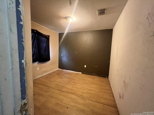 6719 Dragon Fire, San Antonio, TX 78242 - empty room featuring wood finished floors, a textured ceiling, and baseboards