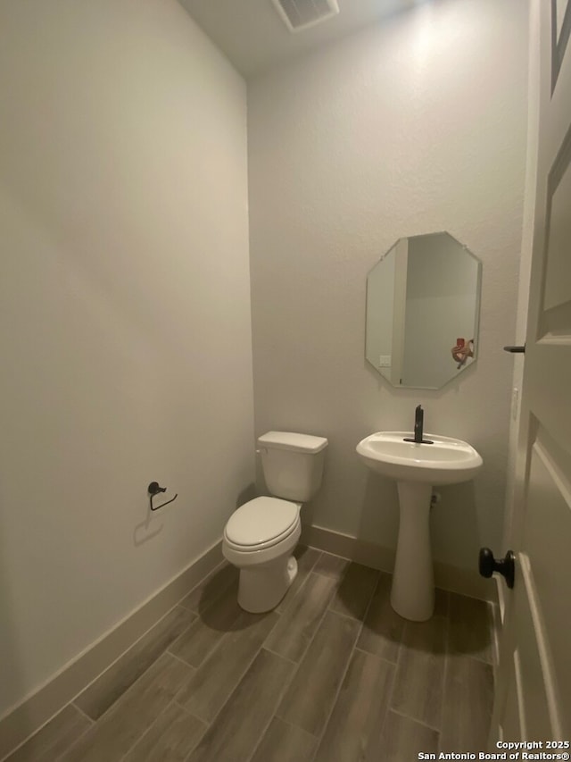 1641 Saddleback Run, New Braunfels, TX 78130 - bathroom with toilet, wood tiled floors, and baseboards