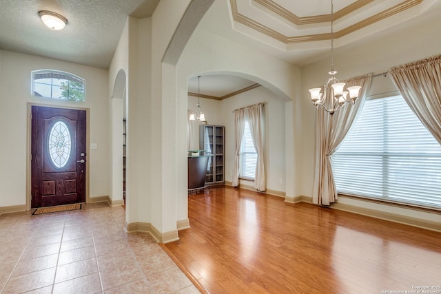 5502 Waldon Walk, San Antonio, TX 78261 - entrance foyer with a chandelier, arched walkways, ornamental molding, baseboards, and light wood-style floors