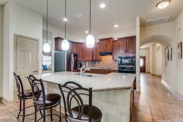 5502 Waldon Walk, San Antonio, TX 78261 - kitchen with black appliances, a sink, light tile patterned floors, arched walkways, and recessed lighting