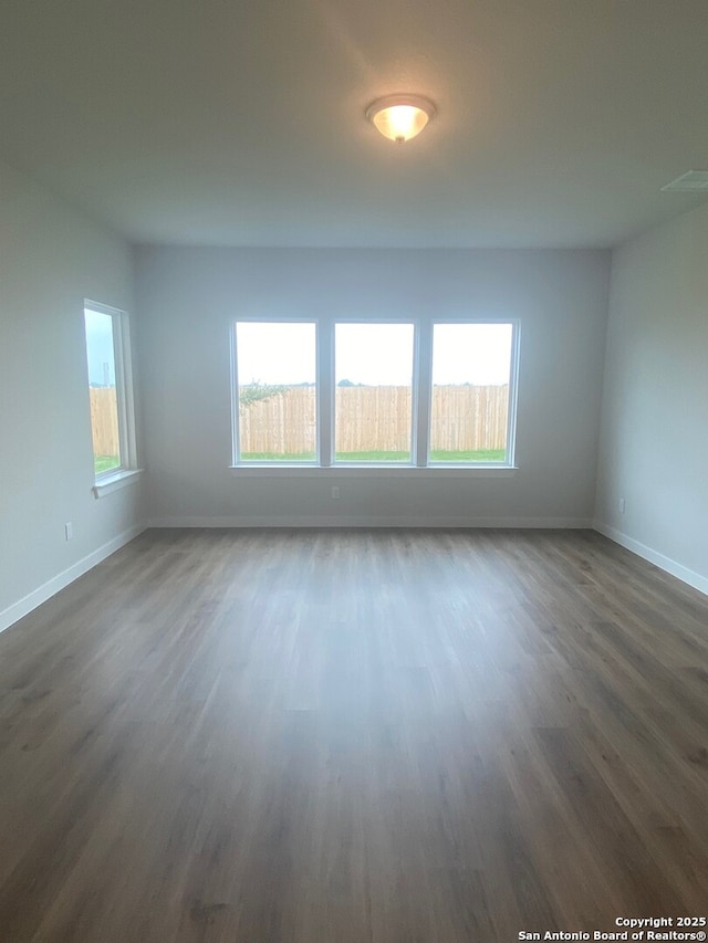 2046 Newforest Peak, New Braunfels, TX 78130 - unfurnished room with healthy amount of natural light, dark wood-type flooring, and baseboards