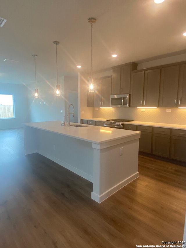 2046 Newforest Peak, New Braunfels, TX 78130 - kitchen featuring stainless steel appliances, a sink, dark wood-style floors, a large island, and light countertops