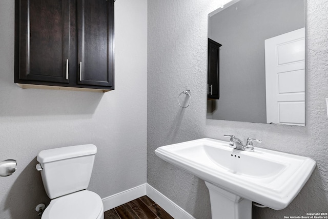 23534 Enchanted Bnd, San Antonio, TX 78260 - bathroom with wood finished floors, a sink, toilet, and baseboards