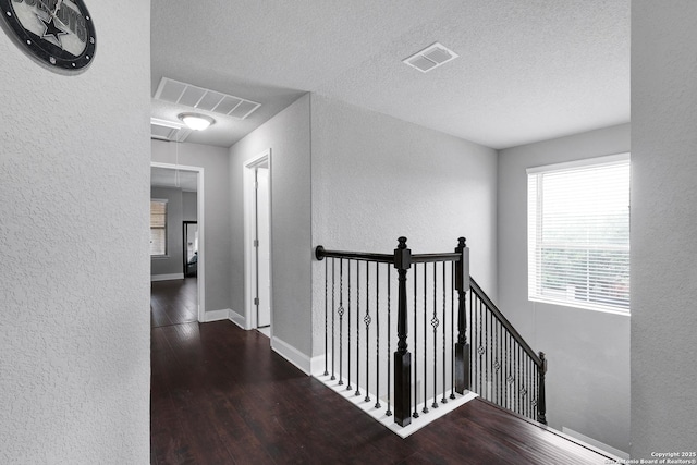 23534 Enchanted Bnd, San Antonio, TX 78260 - hallway with a textured wall, an upstairs landing, attic access, wood finished floors, and a textured ceiling