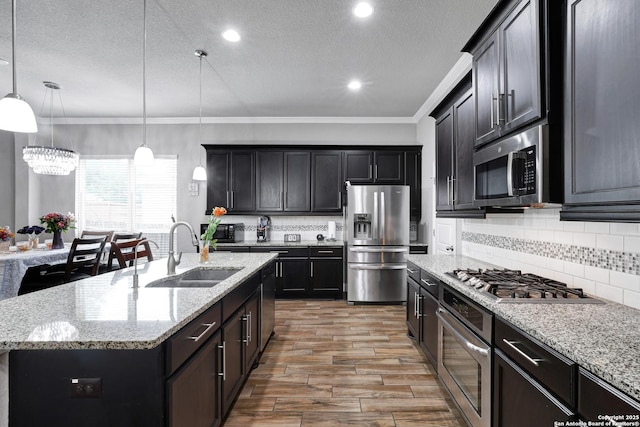 23534 Enchanted Bnd, San Antonio, TX 78260 - kitchen with appliances with stainless steel finishes, a sink, wood finished floors, ornamental molding, and backsplash