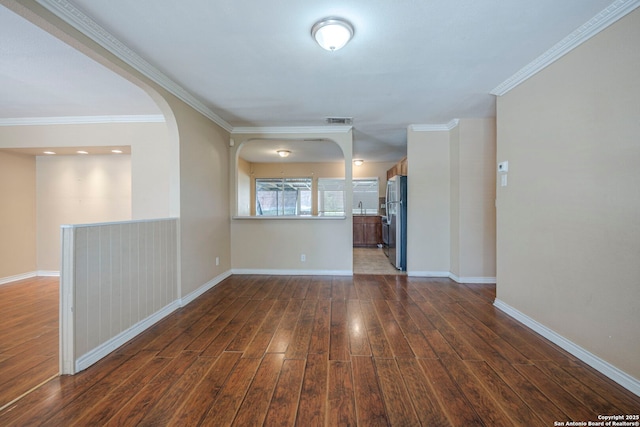 12231 El Santo Way, San Antonio, TX 78233 - unfurnished living room featuring dark wood finished floors, baseboards, ornamental molding, arched walkways, and a sink