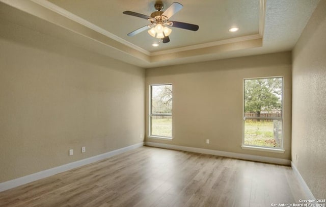 121 E Ashton, Floresville, TX 78114 - unfurnished room featuring plenty of natural light, a tray ceiling, crown molding, wood finished floors, and a ceiling fan