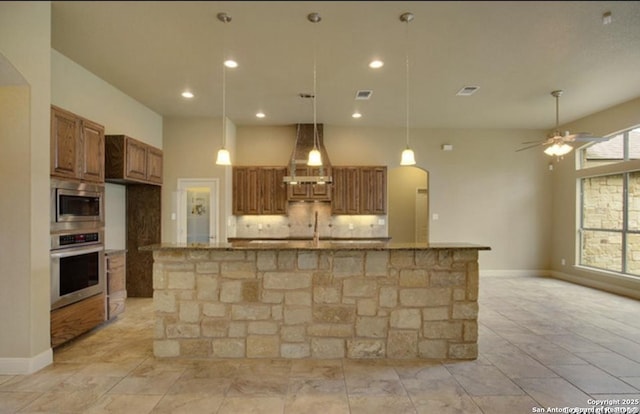 121 E Ashton, Floresville, TX 78114 - kitchen with stainless steel appliances, brown cabinets, backsplash, extractor fan, and stone counters