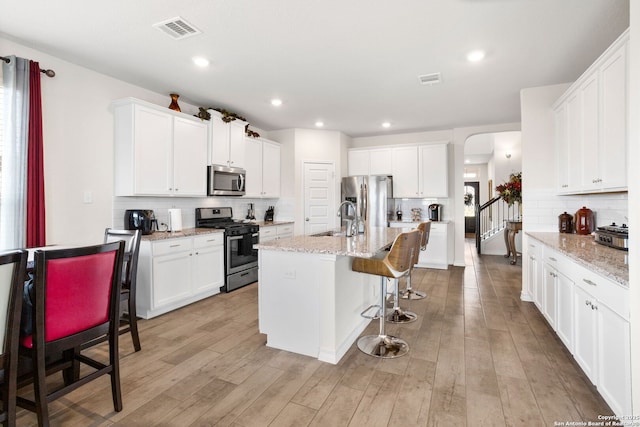 104 Mossy Bank, Cibolo, TX 78108 - kitchen featuring stainless steel appliances, a kitchen bar, tasteful backsplash, a sink, and white cabinets