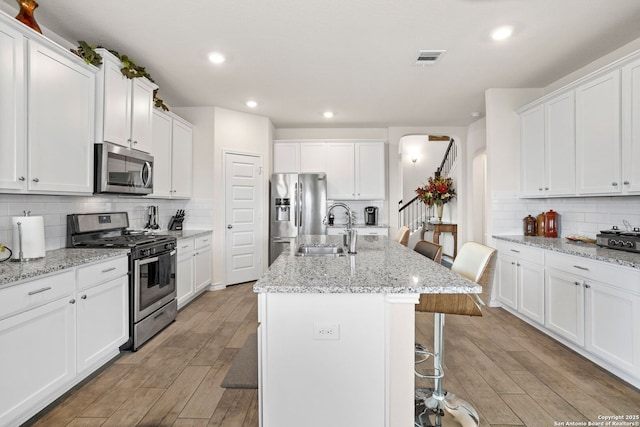104 Mossy Bank, Cibolo, TX 78108 - kitchen featuring stainless steel appliances, a sink, arched walkways, a breakfast bar, and tasteful backsplash