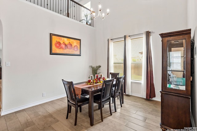 104 Mossy Bank, Cibolo, TX 78108 - dining area featuring arched walkways, light wood finished floors, a chandelier, baseboards, and a high ceiling