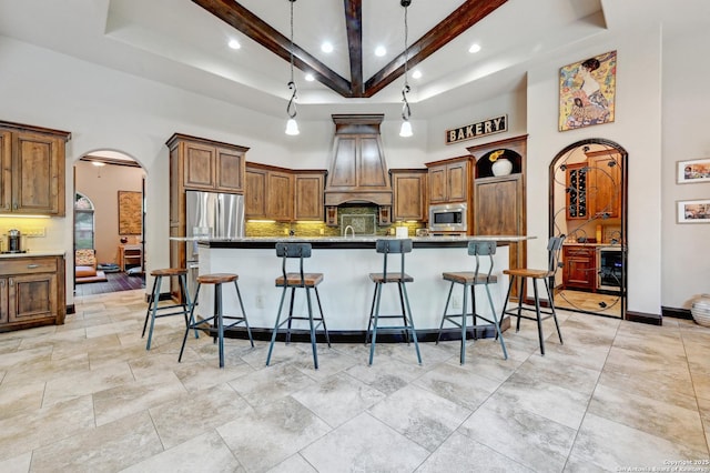kitchen featuring stainless steel appliances, arched walkways, a towering ceiling, recessed lighting, and tasteful backsplash