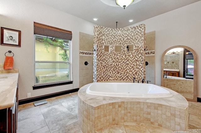 bathroom with a garden tub, walk in shower, and vanity