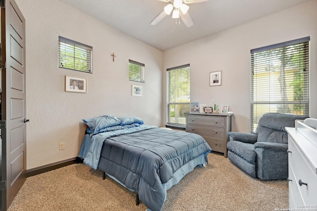 bedroom with light colored carpet, ceiling fan, and baseboards