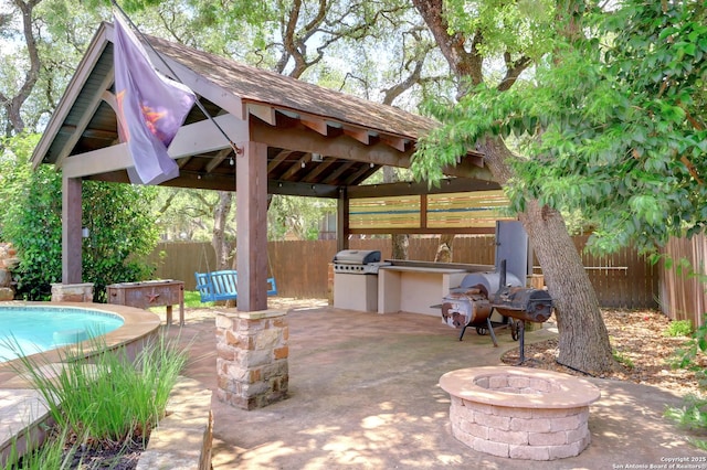 view of patio featuring a gazebo, an outdoor fire pit, area for grilling, a fenced backyard, and grilling area