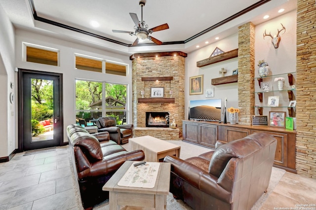 living room featuring a ceiling fan, recessed lighting, a stone fireplace, and ornamental molding