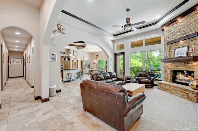 living area featuring ceiling fan, recessed lighting, light tile patterned floors, a fireplace, and arched walkways