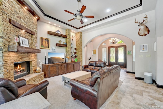 living room with arched walkways, recessed lighting, a raised ceiling, ceiling fan, and baseboards
