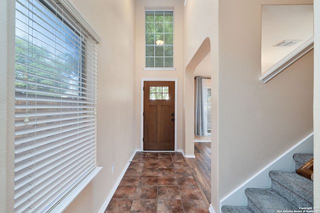 9911 Mustang Isle, San Antonio, TX 78254 - foyer entrance featuring healthy amount of natural light, baseboards, stairs, arched walkways, and a high ceiling