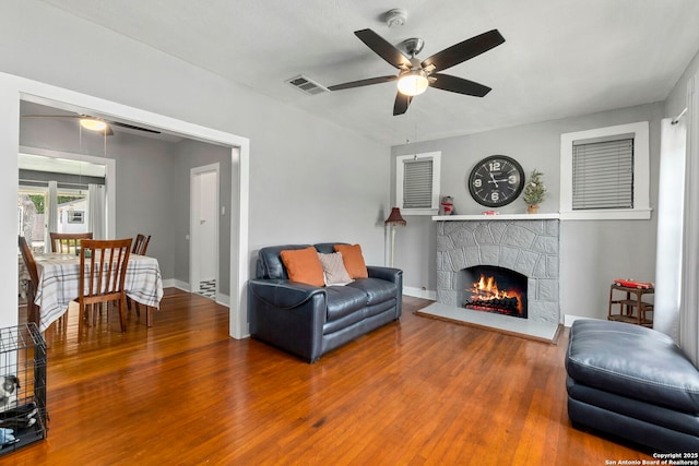 942 Mcilvaine, San Antonio, TX 78201 - living room with a ceiling fan, wood finished floors, a stone fireplace, and baseboards
