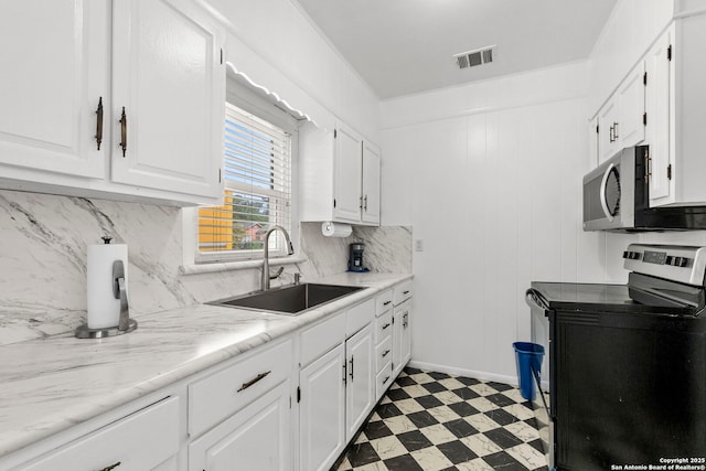 942 Mcilvaine, San Antonio, TX 78201 - kitchen with electric stove, a sink, stainless steel microwave, white cabinets, and light flooring