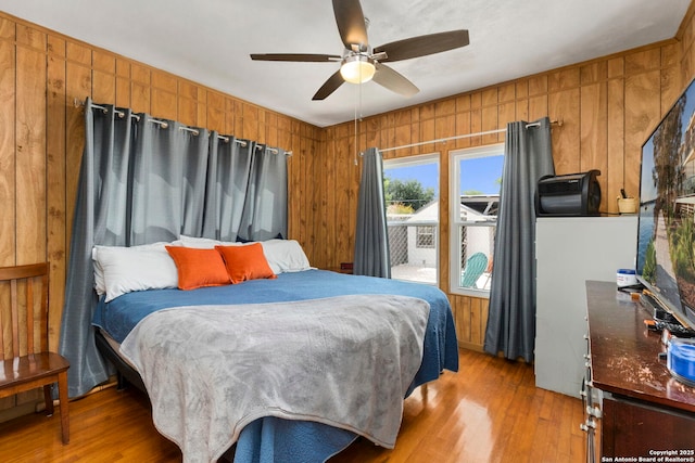 942 Mcilvaine, San Antonio, TX 78201 - bedroom featuring light wood-type flooring, wooden walls, and ceiling fan