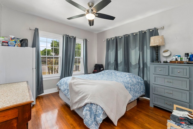 942 Mcilvaine, San Antonio, TX 78201 - bedroom with dark wood-type flooring, freestanding refrigerator, baseboards, and ceiling fan