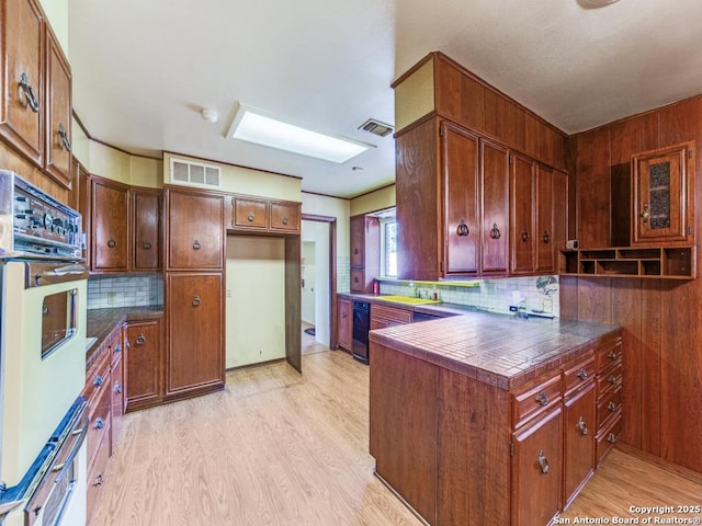 355 Donella, Hollywood Park, TX 78232 - kitchen featuring oven, light wood-style floors, decorative backsplash, and dark countertops