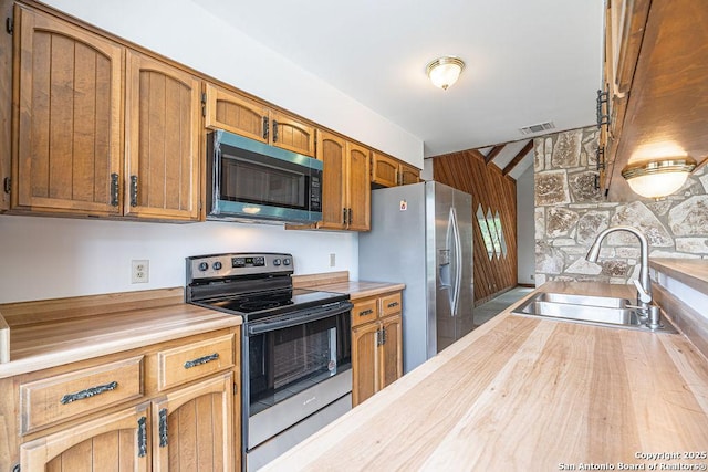 1 Carolyn Ln, Boerne, TX 78006 - kitchen with appliances with stainless steel finishes, a sink, brown cabinetry, and wooden counters