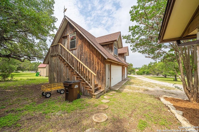 1 Carolyn Ln, Boerne, TX 78006 - view of side of home featuring driveway, stairs, an attached garage, and roof with shingles