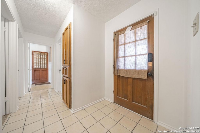 1 Carolyn Ln, Boerne, TX 78006 - doorway with light tile patterned flooring, a textured ceiling, and baseboards