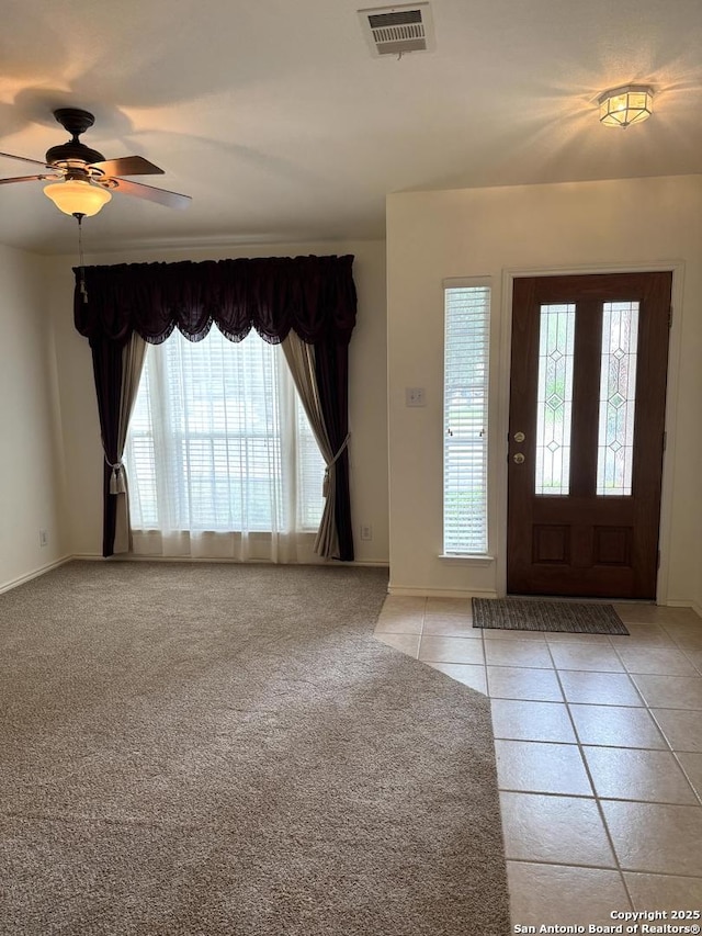 8002 Wever Xing, San Antonio, TX 78250 - foyer entrance with ceiling fan, baseboards, light tile patterned floors, and light carpet