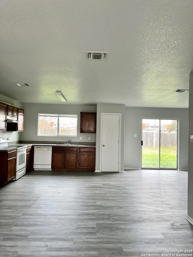 8619 Key N, Converse, TX 78109 - kitchen featuring white appliances, a textured ceiling, light wood-type flooring, under cabinet range hood, and open floor plan