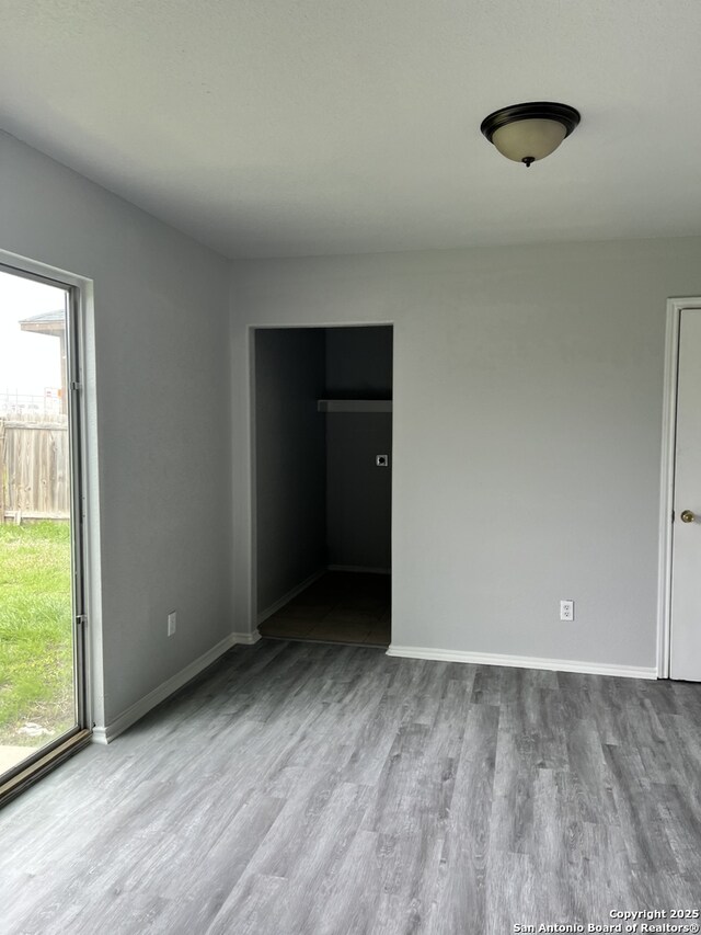 8619 Key N, Converse, TX 78109 - unfurnished bedroom with wood finished floors, multiple windows, and baseboards