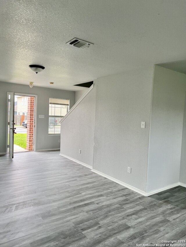 8619 Key N, Converse, TX 78109 - spare room with wood finished floors, baseboards, stairway, and a textured ceiling