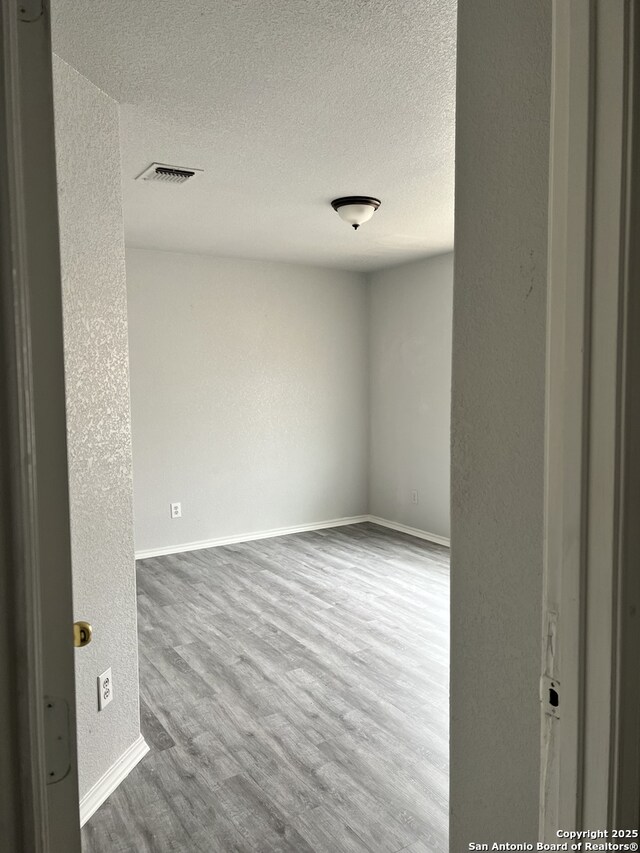 8619 Key N, Converse, TX 78109 - spare room featuring a textured wall, wood finished floors, a textured ceiling, and baseboards