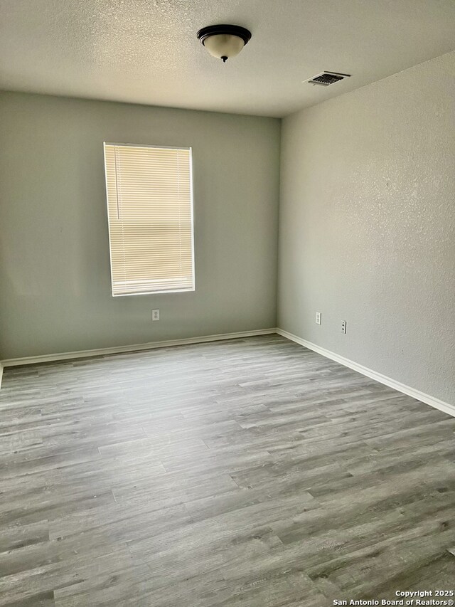 8619 Key N, Converse, TX 78109 - spare room with wood finished floors, baseboards, and a textured ceiling