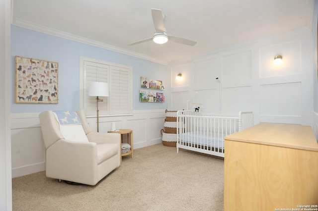 2834 Burning Log, San Antonio, TX 78247 - carpeted bedroom featuring a decorative wall, ornamental molding, a nursery area, wainscoting, and a ceiling fan