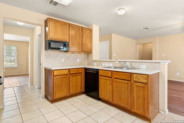 3628 Tilden, New Braunfels, TX 78132 - kitchen featuring black appliances, a peninsula, a sink, light countertops, and backsplash