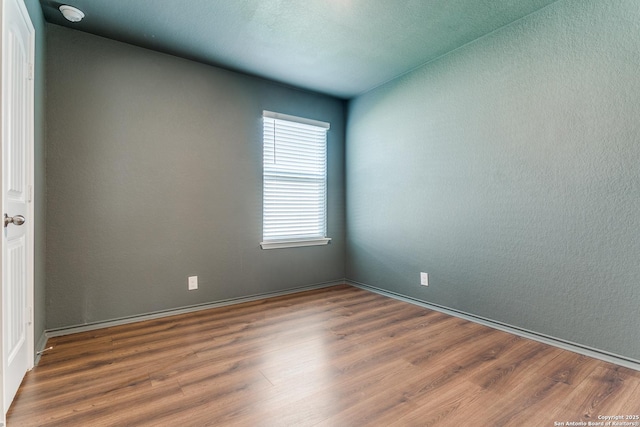 5518 Salado Fls, San Antonio, TX 78222 - spare room with wood finished floors, a smoke detector, and baseboards