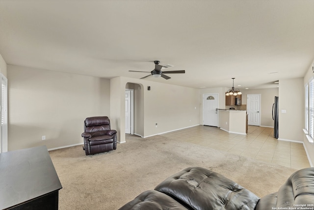 11219 Five Iron, San Antonio, TX 78221 - living area featuring arched walkways, baseboards, a ceiling fan, light tile patterned floors, and light carpet